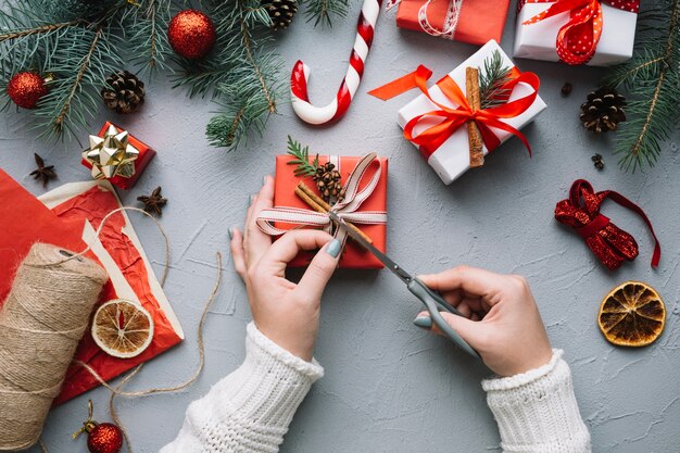 Composição do Natal com as mãos preparando o presente