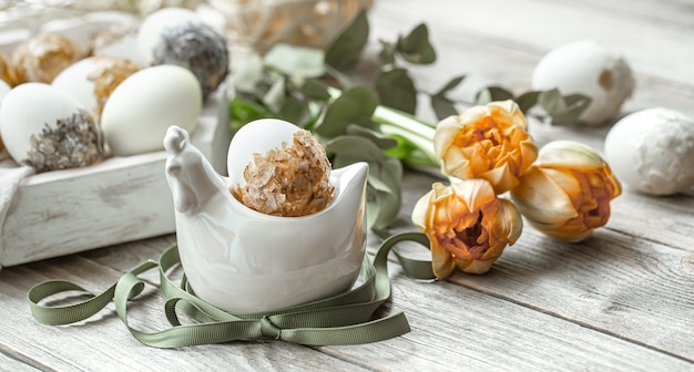 Composição festiva para o feriado da páscoa com ovos decorativos e flores frescas.