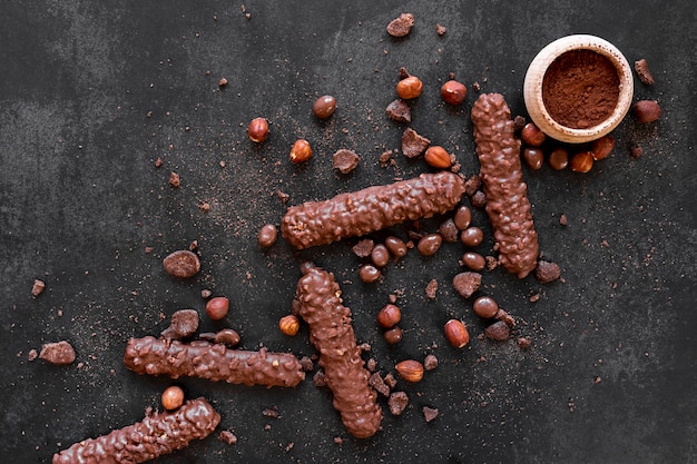 Composição plana de chocolate leigos em fundo escuro