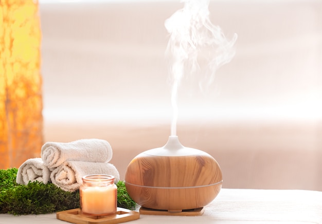 Foto grátis composição spa com aroma de um difusor de óleo moderno com produtos para o corpo