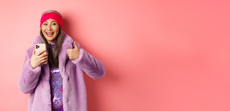 Foto grátis compras on-line e conceito de moda feliz avó asiática verificando promoção incrível apontando dedo