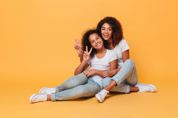 Foto grátis comprimento total de duas irmãs africanas felizes