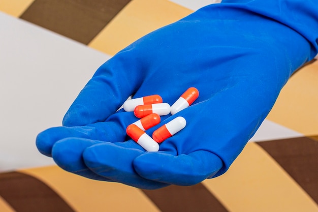 Comprimidos de medicamento de close-up na mão de pessoa