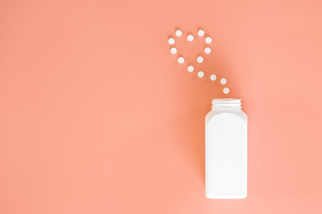Foto grátis comprimidos no conceito de medicina plana leiga de fundo rosa