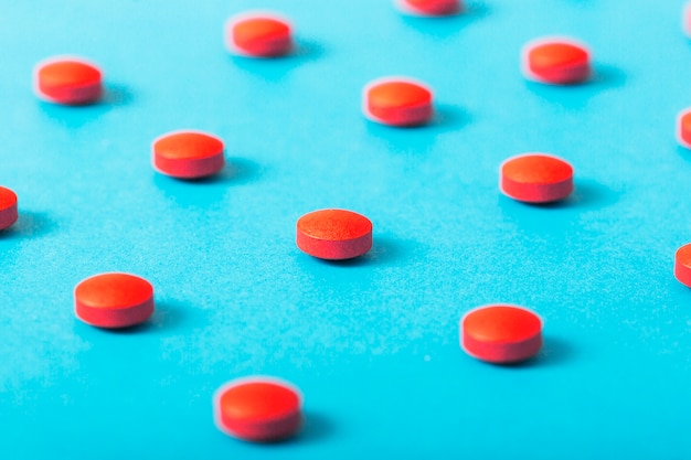 Foto grátis comprimidos vermelhos redondos sobre o pano de fundo azul