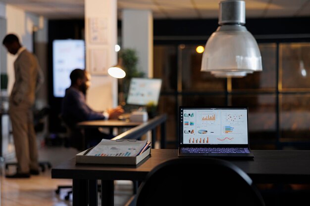 Foto grátis computador portátil com estatísticas de marketing em pé na mesa