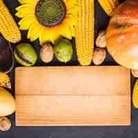 Foto grátis conceito de alimentos de outono com placa de madeira e girassol