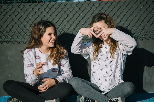 Conceito de amizade com duas garotas sentado no telhado