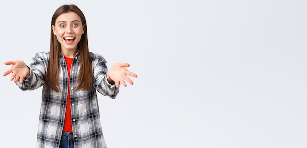 Conceito de atividades de lazer de emoções diferentes de estilo de vida estou feliz por você jovem alegre e animada mulher atraente de camisa xadrez estende as mãos para abraçar e parabenizar o amigo