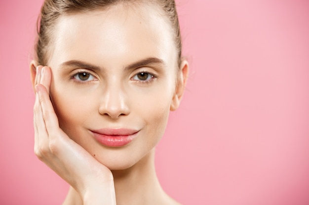 Conceito de beleza - Close up Retrato de garota caucasiano atraente com pele natural de beleza isolada no fundo rosa com espaço da cópia.