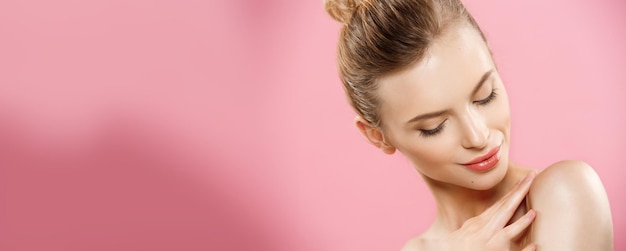 Foto grátis conceito de beleza feche o retrato de uma garota caucasiana atraente com pele natural de beleza isolada em fundo rosa com espaço de cópia