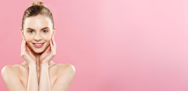 Foto grátis conceito de beleza linda mulher caucasiana com maquiagem natural de pele limpa isolada em fundo rosa brilhante com espaço de cópia