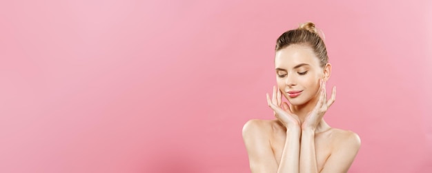 Conceito de beleza Mulher bonita com pele limpa e fresca perto do estúdio rosa Rosto de cuidados com a pele Cosmetologia