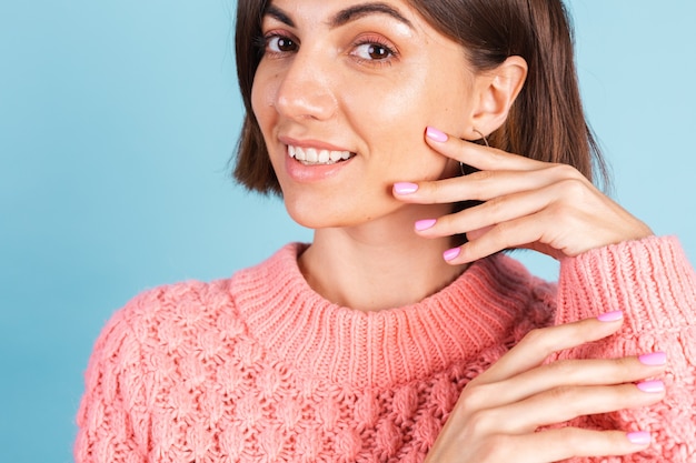 Conceito de beleza, mulher bonita com unhas rosa brilhante manicure na parede