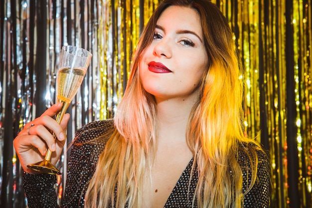 Conceito de celebração de ano novo com mulher segurando copo de champanhe