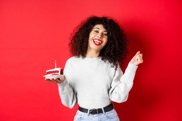 Conceito de celebração e feriados feliz linda mulher dançando e fazendo aniversário desejo segurando bday ...