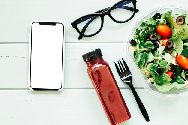 Conceito de comida saudável com suco de smartphone e salada