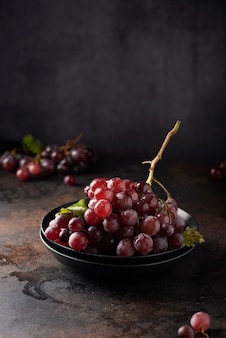 Conceito de comida vegn saudável. uvas vermelhas na mesa preta