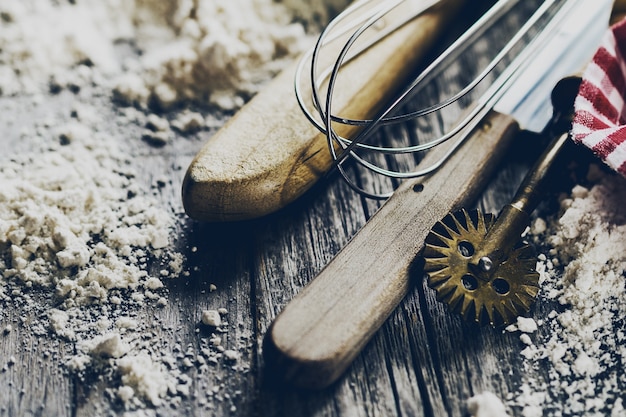 Conceito de cozimento cozinha utensílios de cozinha acessórios para assar no fundo de madeira com farinha. Fechar-se. Processo de cozimento.