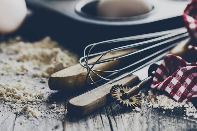 Conceito de cozimento cozinha utensílios de cozinha acessórios para assar no fundo de madeira com farinha. Fechar-se. Processo de cozimento.