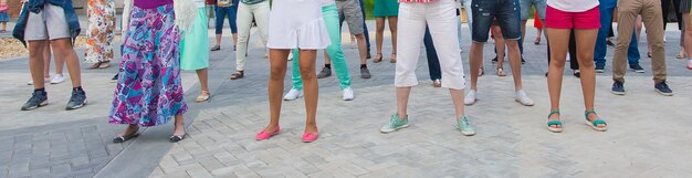 Conceito de dança e flashmob social - diversão e dança com no verão em uma rua da cidade. close-up dos pés dos dançarinos.