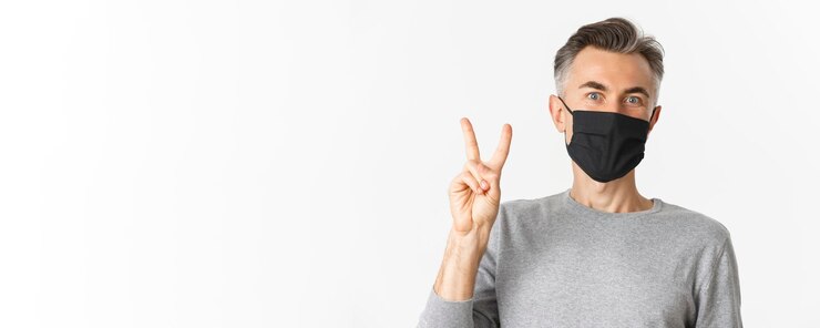 Foto grátis conceito de distanciamento social de covid e quarentena close-up de um homem alegre de meia-idade com máscara médica