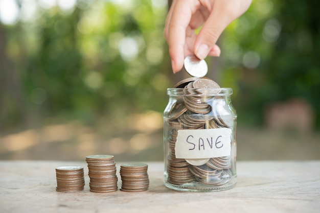 Foto grátis conceito de economia de dinheiro predefinido por masculino mão colocando dinheiro moeda pilha de negócios em crescimento. organize as moedas em pilhas com as mãos, contente com o dinheiro.