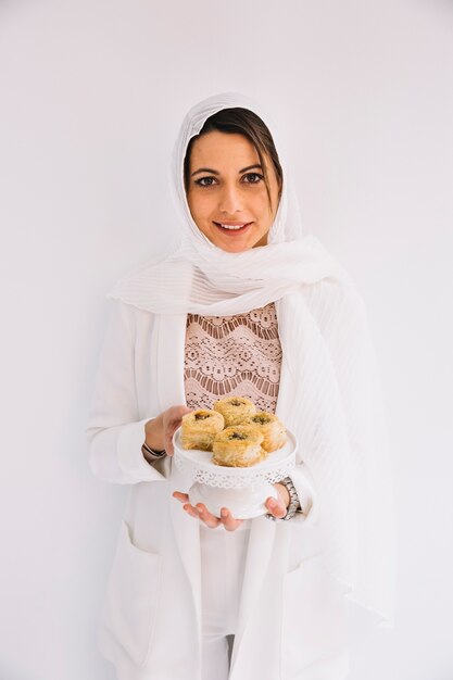 Conceito de Eid com mulher segurando doces árabes