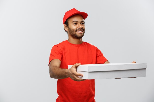 Conceito de entrega - Retrato de Handsome African American Pizza Delivery Man. Isolado no fundo do estúdio cinzento. Espaço de cópia.