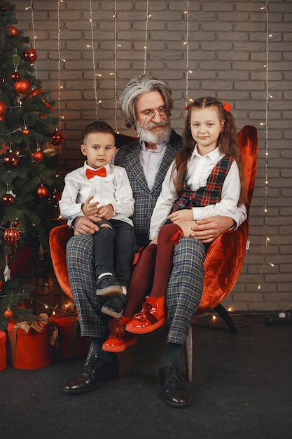 Conceito de família, feriados, geração, natal e pessoas. crianças em um quarto decorado para o natal.