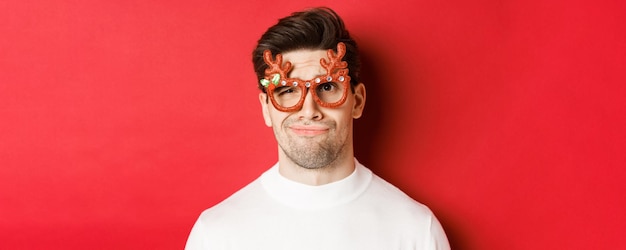 Foto grátis conceito de férias de inverno natal e celebração fechada de homem bonito cético em vidro de festa