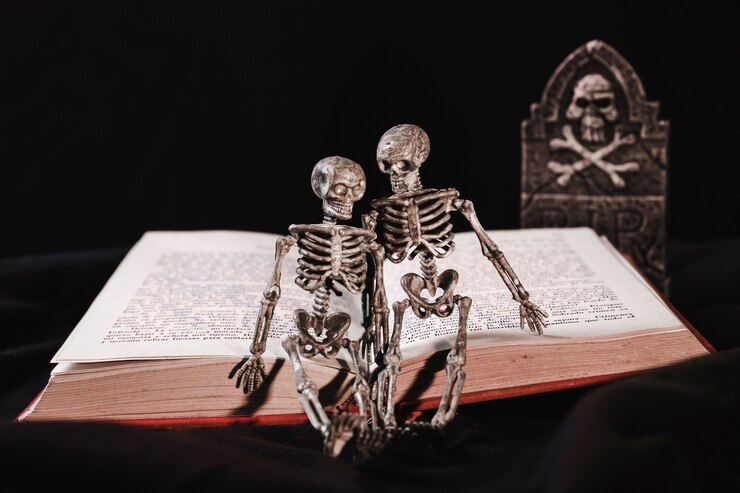 Foto grátis conceito de halloween com esqueleto no livro e lápide