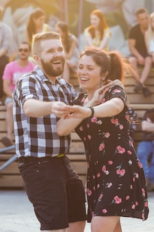 Conceito de kizomba, bachata ou salsa - casal de belezas dançando dança social em festa ao ar livre