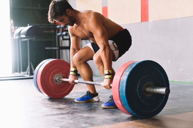 Conceito de musculação com homem forte e barbell