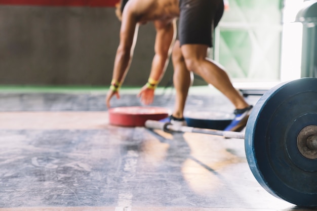 Conceito de musculação com homem tomando placas de peso