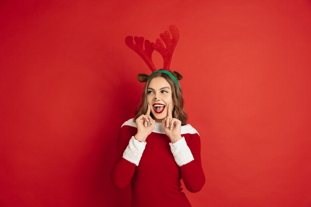 Conceito de Natal, Ano Novo, clima de inverno, feriados. Linda mulher caucasiana com cabelo comprido como a caixa de presente pegando renas do Papai Noel.