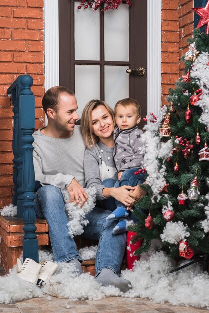 Conceito de Natal com a família jovem sentada fora