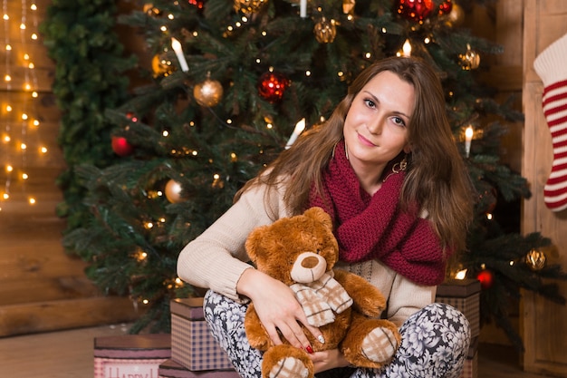 Conceito de Natal com mulher sentada em frente à árvore de Natal