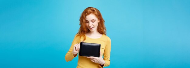 Foto grátis conceito de negócios fecha retrato jovem linda e atraente garota ruiva sorrindo mostrando t digital