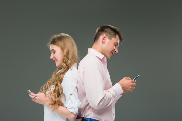 Foto grátis conceito de negócios. os dois jovens colegas segurando telefones móveis em fundo cinza