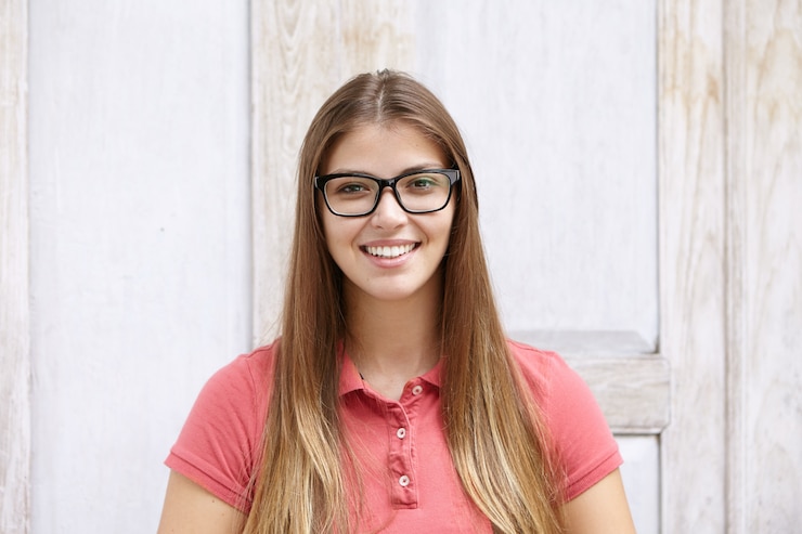 Foto grátis conceito de pessoas e estilo de vida. mulher jovem com cabelo comprido e sorriso alegre e confiante, parecendo feliz
