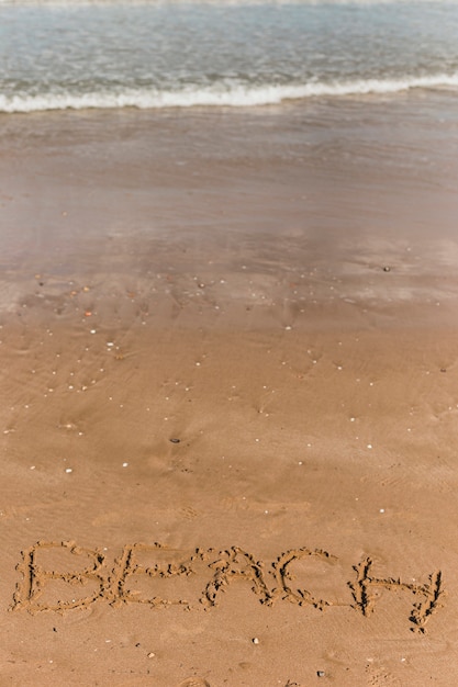 Conceito de praia com letras escritas na areia