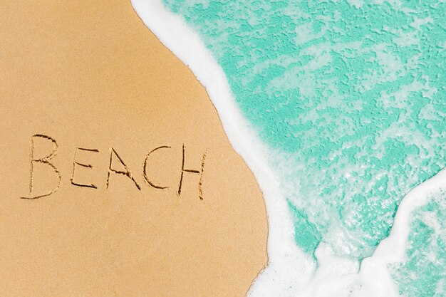Conceito de praia com praia escrita na areia