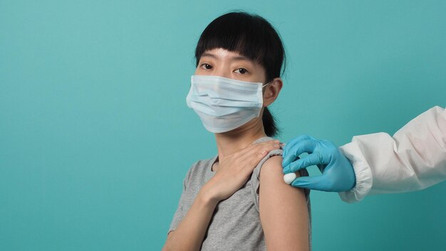 Conceito de prevenção de doenças de imunização de vacinação. mulher com máscara médica tomando covid 19 ou vacina contra a gripe. médico usando algodão antes e depois da injeção. mulher vacinada com coronavírus.