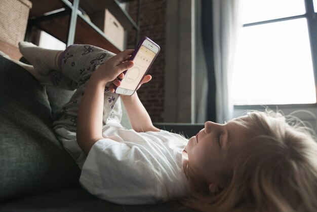 Conceito de tecnologia com menina brincando com smartphone