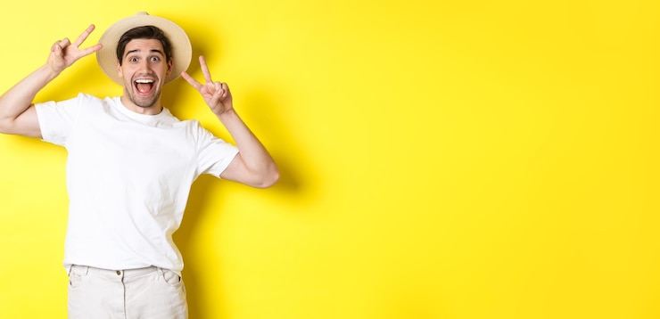 Foto grátis conceito de turismo e férias turista masculino feliz posando para foto com sinais de paz sorrindo animado