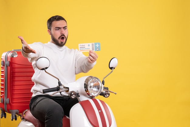 Conceito de viagens com um homem nervoso sentado em uma motocicleta com uma mala mostrando o bilhete amarelo