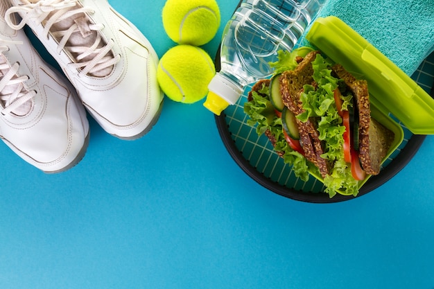 Foto grátis conceito de vida saudável para o esporte. toalha, sanduíche saudável e garrafa de água em fundo brilhante. espaço de cópia. acima.