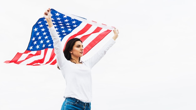 Conceito do dia da independência com a mulher segurando a bandeira no fundo do céu