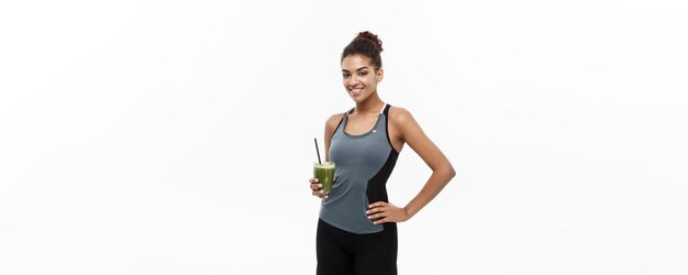 Conceito saudável e fitness linda garota afro-americana em roupas esportivas segurando água plástica
